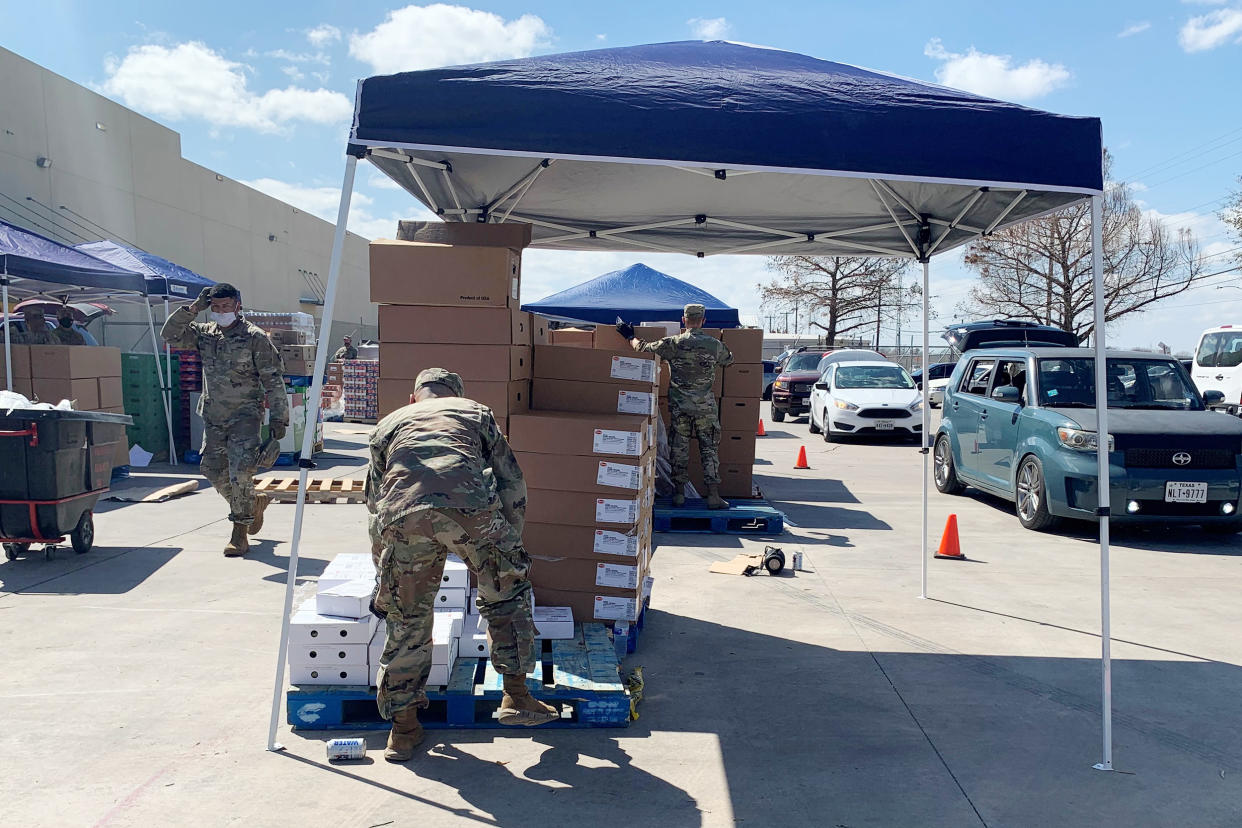 Texas National Guard members help load cars at the San Antonio Food Bank's afternoon distribution on Feb. 23, 2021. (Suzanne Gamboa / NBC News)