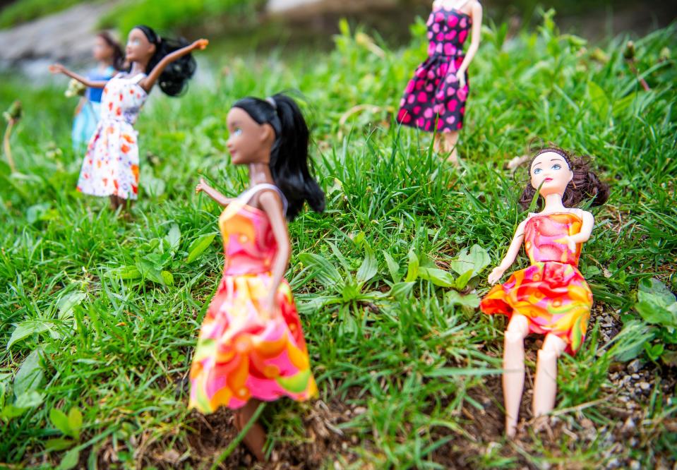 A toy doll, right, found during the clean-up is returned to its original display spot during the Campus River clean-up on Friday, April 12, 2024.