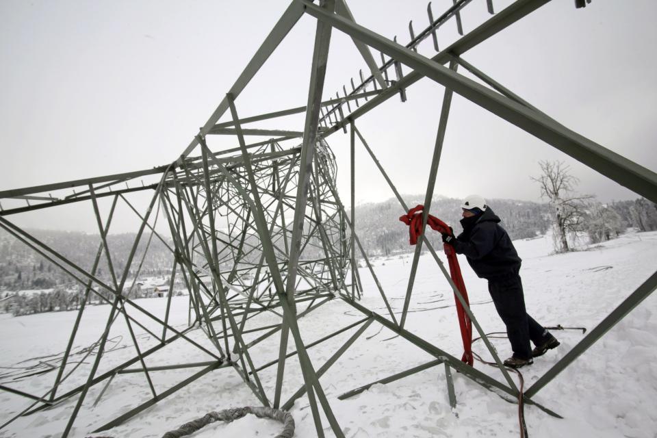 Un trabajador remueve una torre eléctrica vencida en Strmca. REUTERS/Srdjan Zivulovic