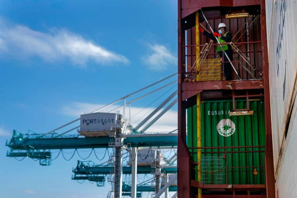 A longshoreman works to unhook containers inside a docked cargo ship at PortMiami on Saturday, February 20, 2021.