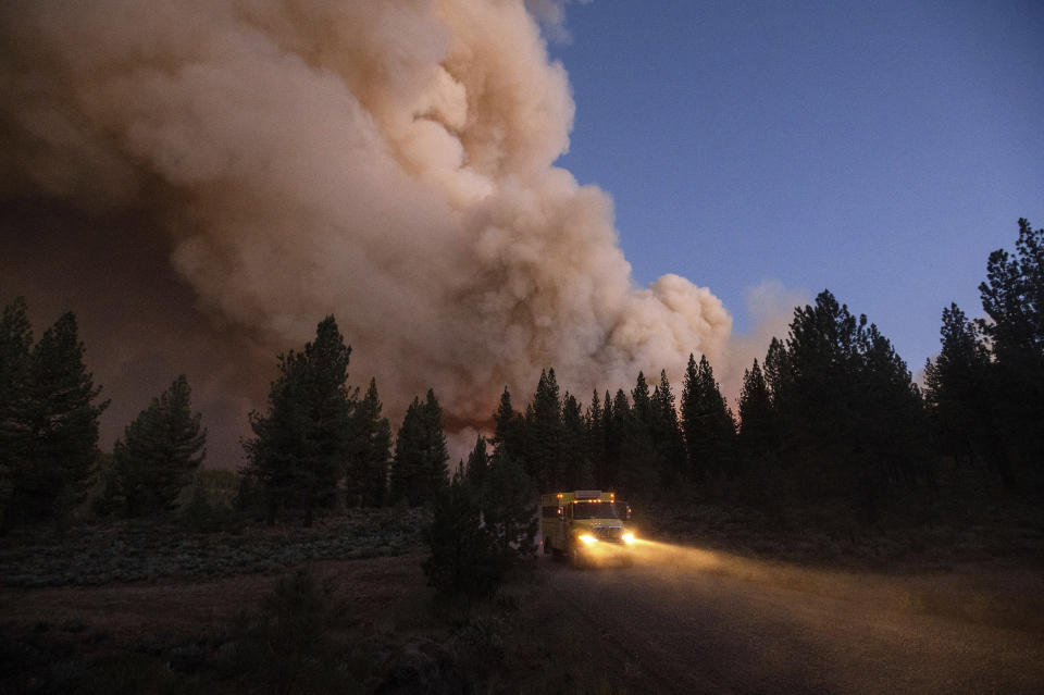 A plume of smoke rises over a roadway as the Sugar Fire, part of the Beckwourth Complex Fire, burns in Plumas National Forest, Calif., on Thursday, July 8, 2021. (AP Photo/Noah Berger)