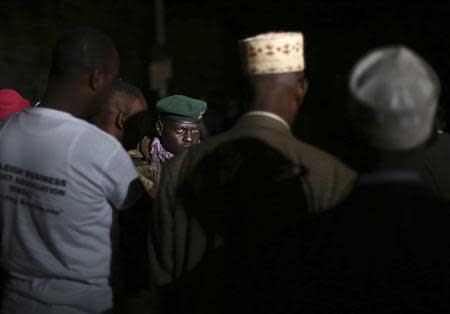 A Kenyan soldier looks at members of the Somali community living in Nairobi, as they deliver food and drinks to soldiers and security personnel near the Westgate shopping centre in Nairobi September 23, 2013. REUTERS/Karel Prinsloo