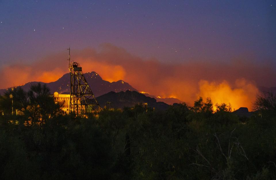 The Bush Fire burns in the Tonto National Forest behind the Goldfield Ghost Town on June 16, 2020. Multiple communities in the path of a rapidly growing fire have been ordered to evacuate from the human-caused brush fire.