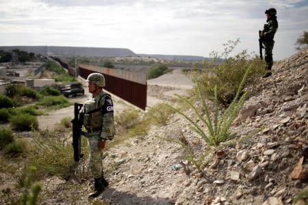 FILE PHOTO - Soldiers assigned to the National Guard keep watch near a section of the border fence between Mexico and U.S. as seen from Anapra neighborhood in Ciudad Juarez