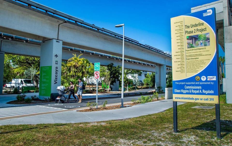 Una pareja empuja un cochecito de bebé frente a la estación del Metrorail de Vizcaya, en el nuevo tramo de dos millas del sendero urbano y parque lineal The Underline, que se inaugurará el 24 de abril de 2024.