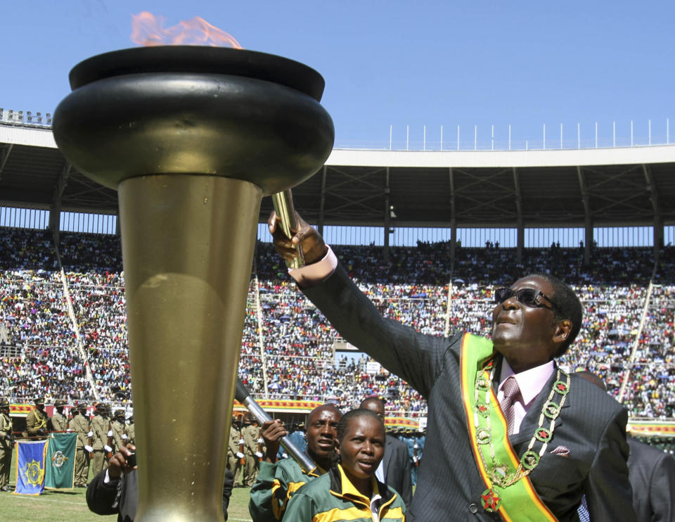 FILE - In this Wednesday, April 18, 2012 file photo Zimbabwe President Robert Mugabe, lights a flame at celebrations to mark 32 years of independence of Zimbabwe, in Harare. On Friday, Sept. 6, 2019, Zimbabwe President Emmerson Mnangagwa said his predecessor Mugabe, age 95, has died. (AP Photo/File)