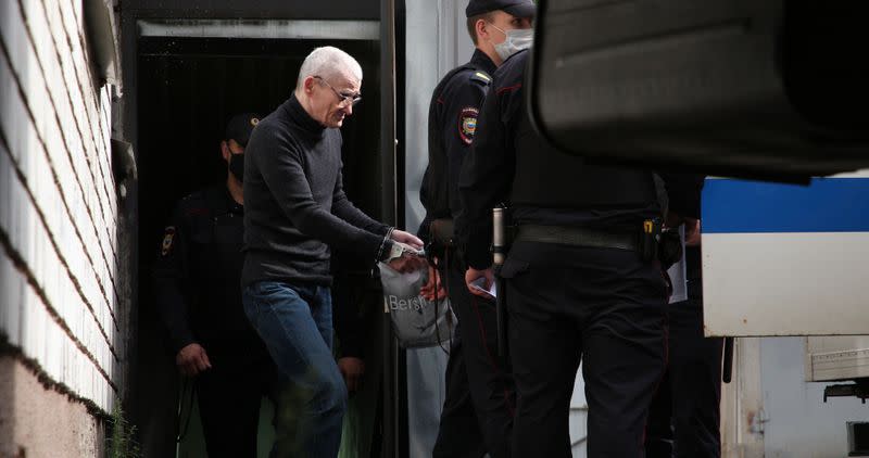 Russian historian Yuri Dmitriev is escorted by police officers after a court hearing in Petrozavodsk