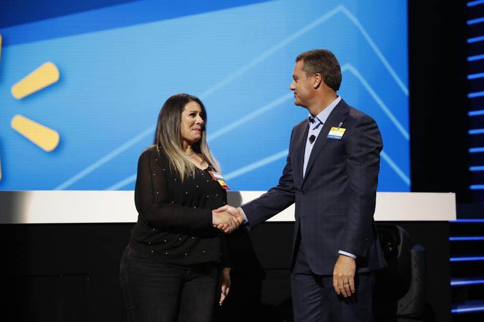 Doug McMillon President and CEO Walmart Inc. presents a promotion to Shabnam Ighani at the 2019 Walmart Shareholders June 7, 2019 in Bud Walton Arena, Fayetteville, Arkansas.