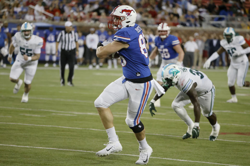 SMU tight end Tommy McIntyre (86) runs after catching a touchdown pass in front of Tulane linebacker Kevin Henry (33) during the first half of an NCAA college football game in Dallas, Thursday, Oct. 21, 2021. (AP Photo/Michael Ainsworth)