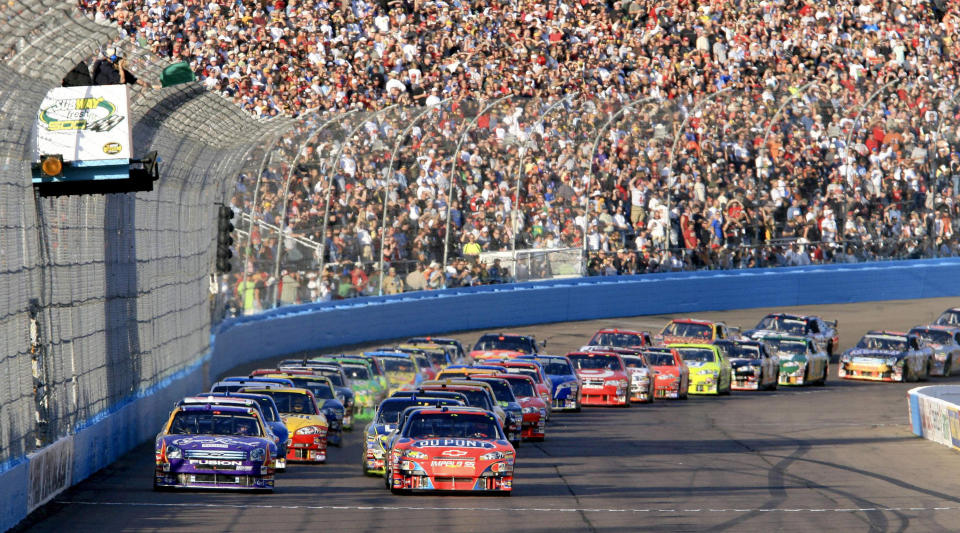 FILE -Drivers take the green flag to start the Subway Fresh Fit 500 NASCAR auto race on Saturday, April 21, 2007, in Avondale, Ariz. NASCAR’s next 75 years almost certainly will include at least a partially electric vehicle turning laps at Daytona International Speedway. It’s unfathomable to some, unconscionable to others. (AP Photo/Ken Sklute, File)