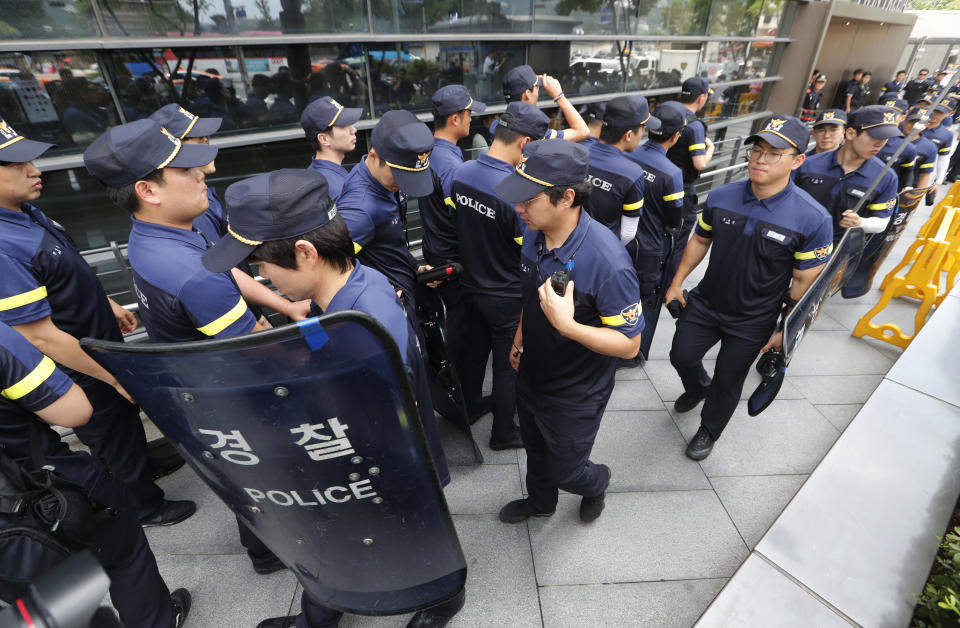 South Korean police officers arrive to guard for possible rallies against Japan in front of a building which houses Japanese embassy in Seoul, South Korea, Friday, Aug. 2, 2019. Japan's Cabinet on Friday approved the removal of South Korea from a "whitelist" of countries with preferential trade status, a move sure to fuel antagonism already at a boiling point over recent export controls and the issue of compensation for wartime Korean laborers. (AP Photo/Ahn Young-joon)