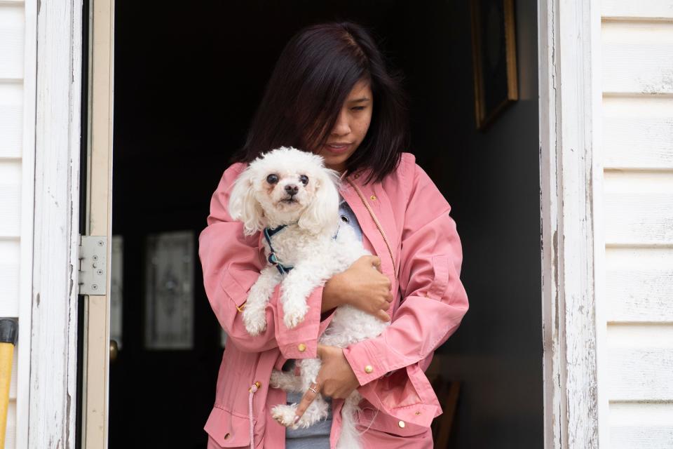 Fatima Quintana picks up her dog after attending school at Spartanburg High School Monday, March 2, 2020.