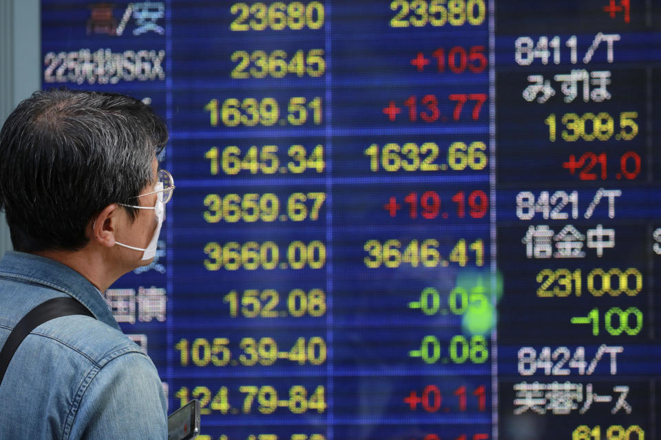 A man looks at an electronic stock board of a securities firm in Tokyo, Wednesday, Oct. 21, 2020. Asian shares mostly rose Wednesday, cheered by the gains on Wall Street as investors welcomed a batch of solid earnings reports from U.S. companies.(AP Photo/Koji Sasahara)