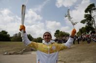 Olympics - Dress Rehearsal - Lighting Ceremony of the Olympic Flame Pyeongchang 2018 - Ancient Olympia, Olympia, Greece - October 23, 2017 First torchbearer Greek cross country skiing athlete Apostolos Aggelis holds the Olympic Flame and an olive branch during the dress rehearsal for the Olympic flame lighting ceremony for the Pyeongchang 2018 Winter Olympic Games at the site of ancient Olympia in Greece REUTERS/Alkis Konstantinidis
