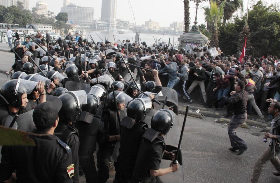 FILE - In this Jan. 25, 2011 file photo, police face demonstrators in Cairo, during a Tunisia-inspired demonstration to demand the end of President Hosni Mubarak's nearly 30 years in power. As Egyptians mark the third anniversary of their revolution against autocrat Hosni Mubarak in the name of democracy, there has been a powerful sign of the country’s stunning reversals since: letters of despair by some of the prominent activists who helped lead the uprising, leaked from the prisons where they are now jailed. The letters show a daunted and broken spirit, no longer speaking of imminent democracy, but of injustices and a failed struggle.(AP Photo, File)