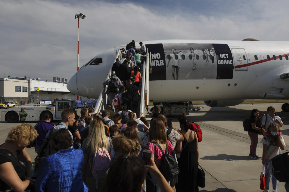 Ukrainian refugees board a plane before flying to Canada, from Frederic Chopin Airport in Warsaw, Poland, Monday, July 4, 2022. Phan Thị Kim Phuc, the girl in the famous 1972 Vietnam napalm attack photo, on Monday escorted 236 refugees from the war in Ukraine on a flight from Warsaw to Canada. Phuc’s iconic Associated Press photo in which she runs with her napalm-scalded body exposed, was etched on the private NGO plane that is flying the refugees to the city of Regina. (AP Photo/Michal Dyjuk)