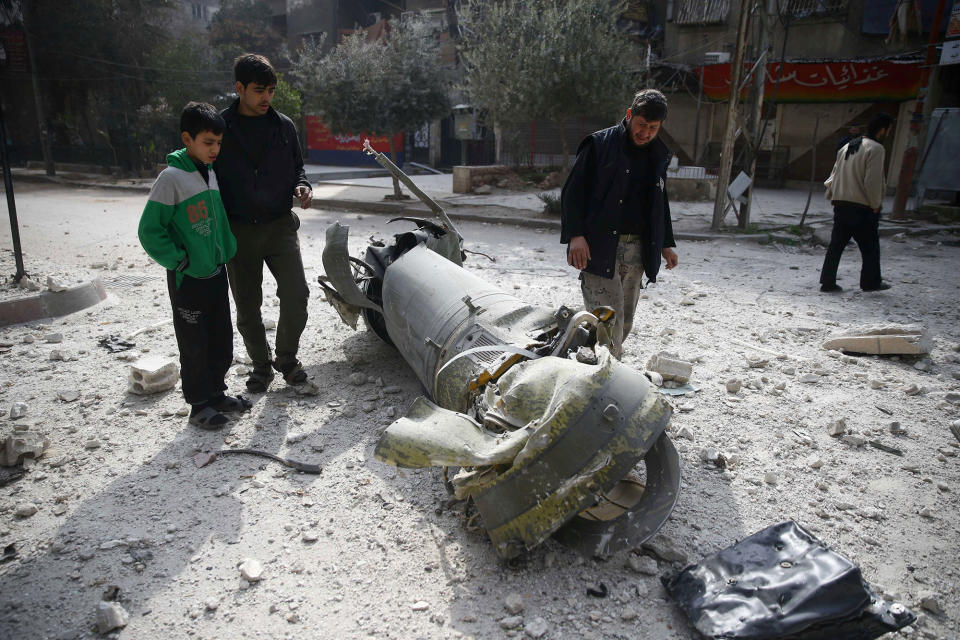 <p>People inspect missile remains in the besieged town of Douma, in eastern Ghouta, in Damascus, Syria, Feb. 23, 2018. (Photo: Bassam Khabieh/Reuters) </p>