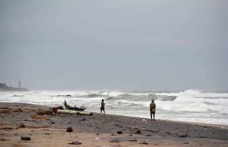 Fishermen walk along the shore before being evacuated, at Visakhapatnam district in Andhra Pradesh October 11, 2014. REUTERS/R Narendra