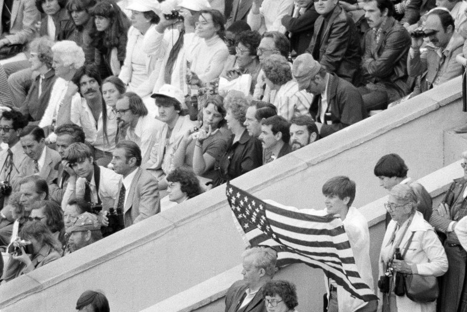 FILE - In this July 19, 1980, file photo, an unidentified youth displays the flag of the United States during opening ceremonies at the Summer Olympic Games in Moscow, The United State did not attend the Olympics in Moscow but rather led a boycott in protest of Soviet intervention in Afghanistan. (AP Photo/File)
