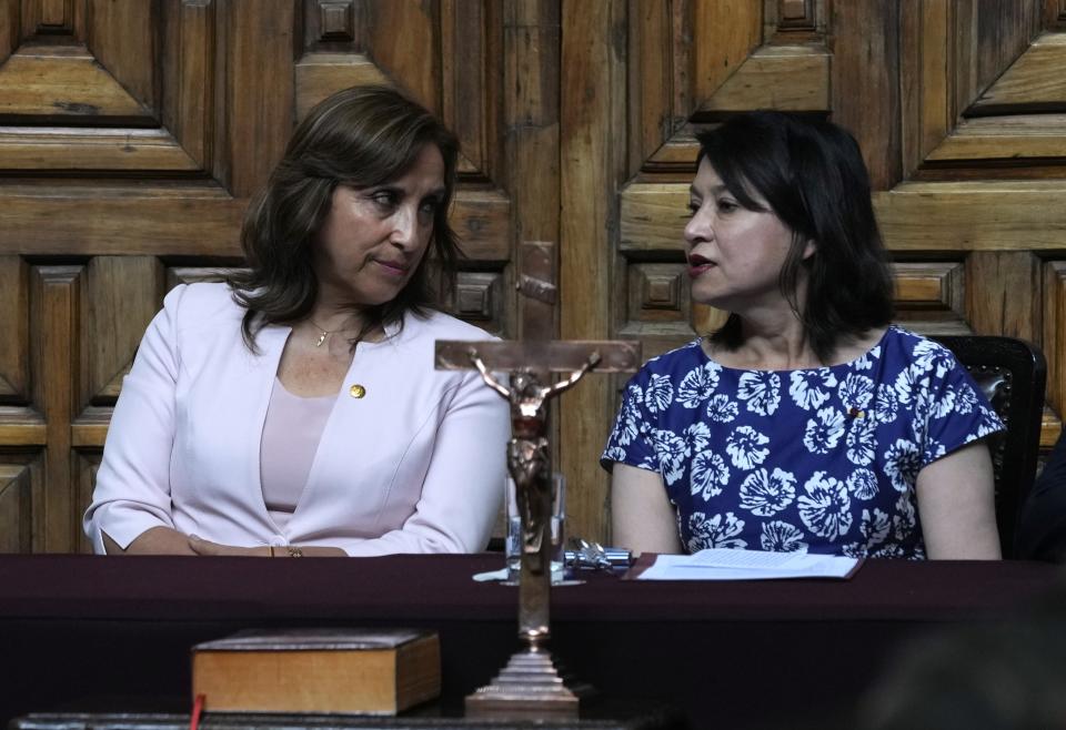 Peru's President Dina Boluarte, left, talks to Foreign Minister Ana Cecilia Gervasi during a ceremony at the Foreign Ministry in Lima, Peru, Tuesday, Dec. 20, 2022. Peru's Congress is slated to consider a proposal on Tuesday to push up elections that have been a major demand of protesters blocking highways and clashing with security forces in deadly demonstrations across the country over the ouster of President Pedro Castillo. (AP Photo/Martin Mejia)