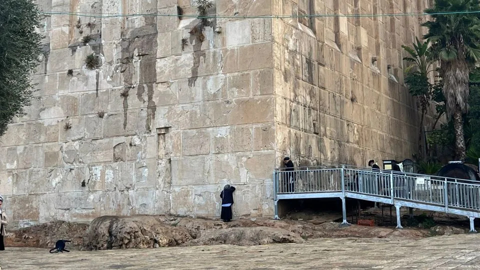 People pray on the exterior wall of the Cave of the Patriarchs on November 17 in Hebron, West Bank. - Tara John/CNN