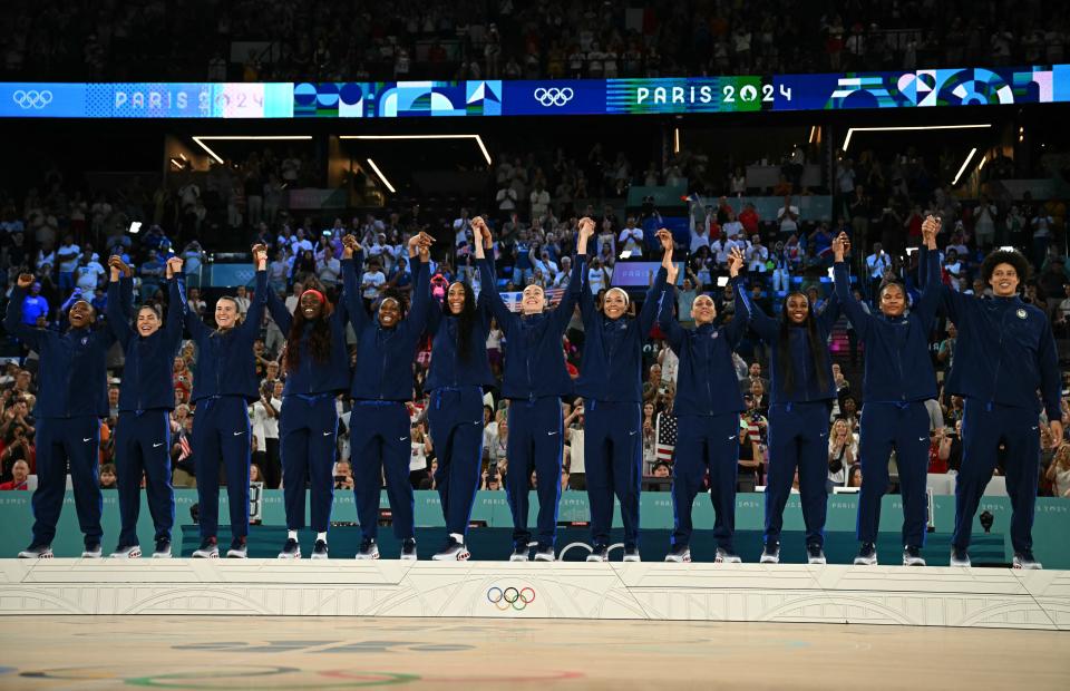 Gold medallists USA celebrate on the podium after the women's Gold Medal basketball match between France and the USA during the Paris 2024 Olympic Games at the Bercy Arena in Paris on August 11, 2024. (Photo by Paul ELLIS / AFP) (Photo by PAUL ELLIS/AFP via Getty Images) ORIG FILE ID: 2165853508