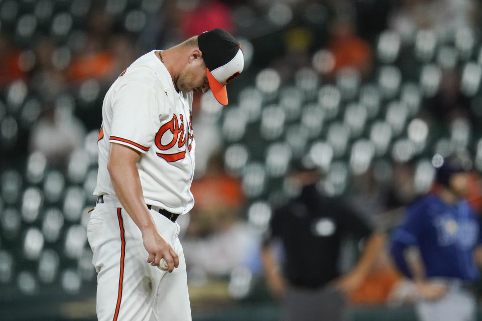 Baltimore Orioles relief pitcher Travis Lakins Sr. reacts after allowing an RBI single by Tampa Bay Rays' Brandon Lowe that scored Randy Arozarena during the sixth inning of a baseball game, Tuesday, May 18, 2021, in Baltimore. (AP Photo/Julio Cortez)