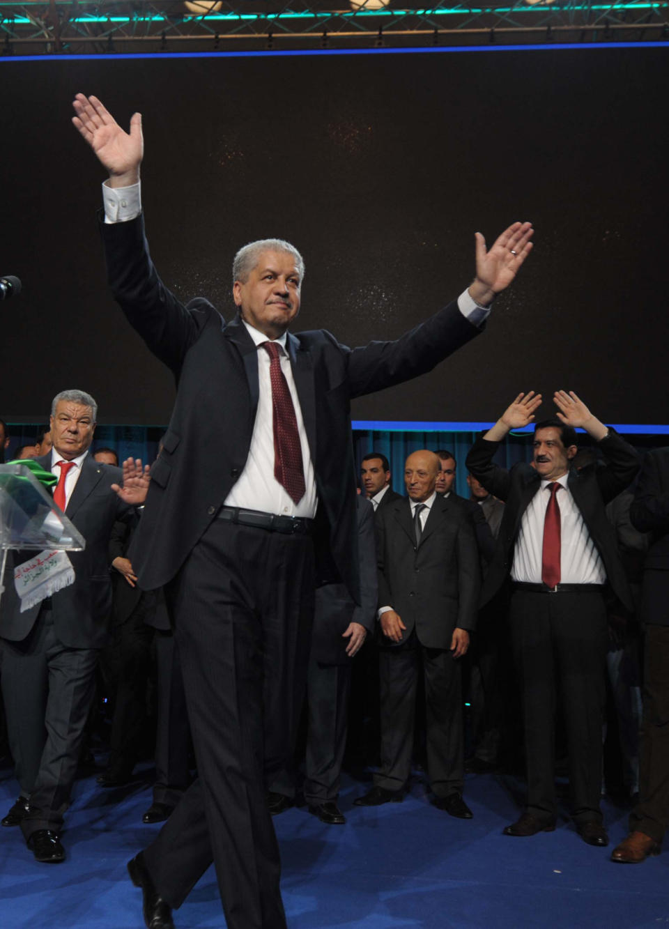 President Abdelaziz Bouteflika's campaign manager, Abdelmalek Sellal, waves to supporters as part of a presidential campaign meeting in the Algerian capital, Algiers, Sunday, April 13, 2014. President Abdelaziz Bouteflika, who will be running for his fourth five-year term, will be largely sitting out the campaign and relying on deputies to present his case after a stroke last year left the 77-year-old in a wheelchair with trouble speaking. Six candidates are running for the powerful presidency in the April 17 elections. (AP Photo/Sidali Djarboub)