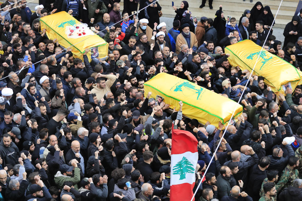 Mourners carry the coffins of a Hezbollah fighter and other two civilians who killed by an Israeli airstrike that hit their house Tuesday night, in Bint Jbeil, South Lebanon, Wednesday, Dec. 27, 2023. One Hezbollah fighter and two civilians, a newlywed couple, were killed in an overnight Israeli strike on a family-owned residential building in the town of Bint Jbeil, local residents and state media said Wednesday.(AP Photo/Mohammed Zaatari)