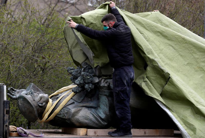 FILE PHOTO: A worker covers the statue of Soviet World War II commander Ivan Stepanovic Konev after removal from its platform in Prague