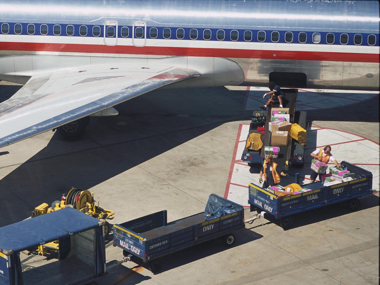 American Airlines' baggage handlers transport passenger's goods at Dallas-Fort Worth International Airport.