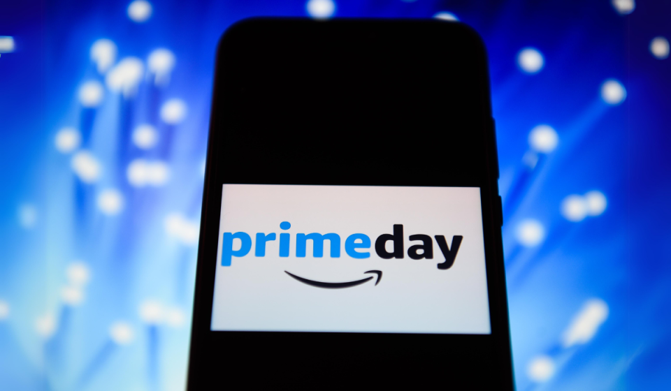 phone with Amazon Prime Day logo image on the screen against a blue and white background