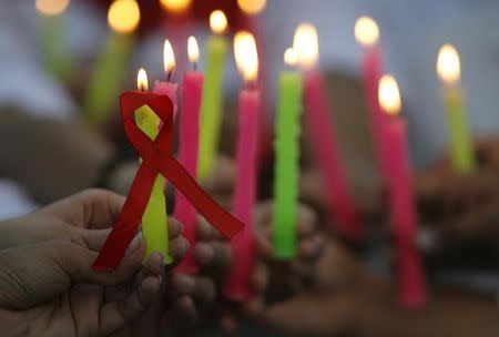 People hold candles during a HIV/AIDS awareness campaign to mark World AIDS Day in the northern Indian city of Chandigarh December 1, 2011. REUTERS/Ajay Verma (INDIA - Tags: HEALTH ANNIVERSARY) - RTR2UP6S