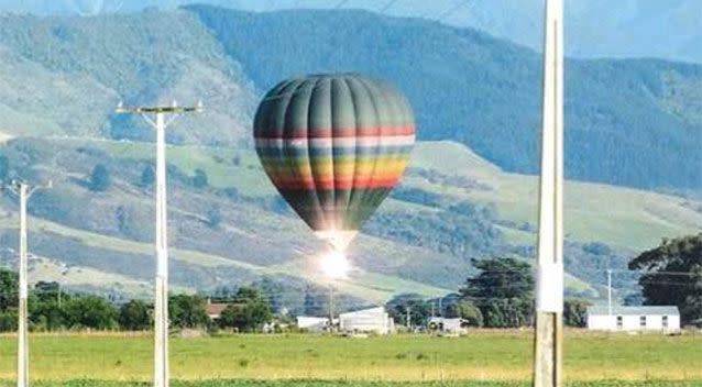 A flash of light as the basket of the hot air balloon makes contact withe the power lines. Photo: Geoff Walker.