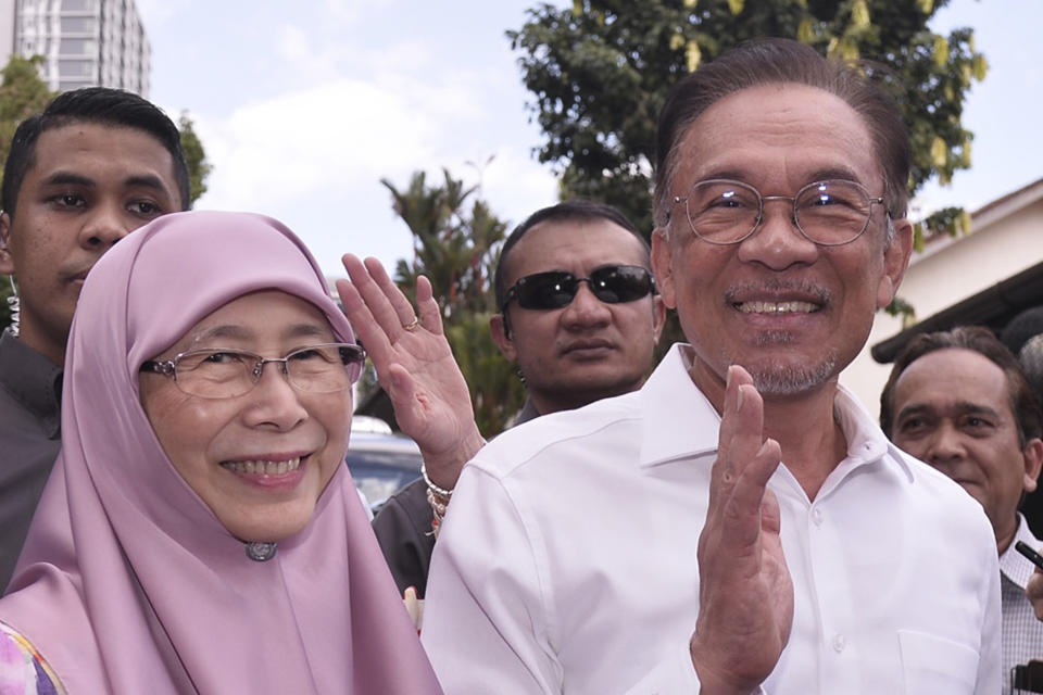 Politician Anwar Ibrahim, right, and his wife Wan Azizah Ismail waves as they heading to their party headquarters for a press conference after meeting the king in Kuala Lumpur, Malaysia, Wednesday, Feb. 26, 2020. Malaysia's king held unusual consultations with lawmakers for a second day Wednesday to resolve a political vacuum caused by the abrupt collapse of the ruling coalition and the resignation of Prime Minister Mahathir Mohamad. (AP Photo)