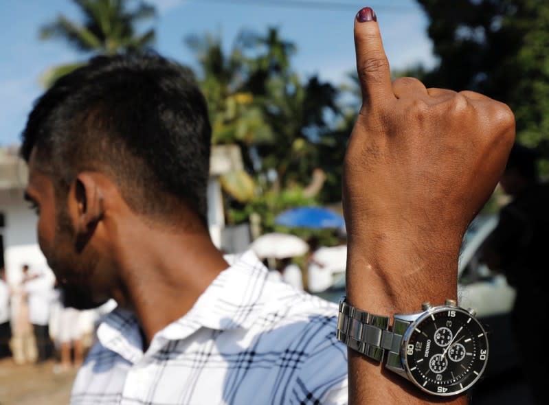 A man shows his inked finger after casting his vote during the presidential election, at a polling station in Colombo