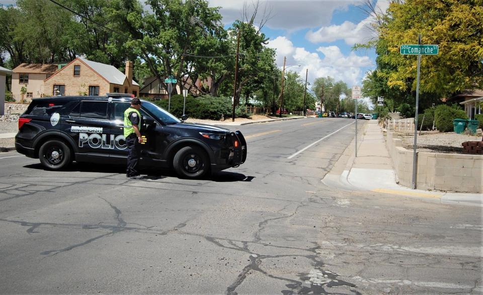 A Farmington police officer mans a roadblock at the corner of North Dustin Avenue and East Comanche Street on Monday, May 15 after a shooting in the area.