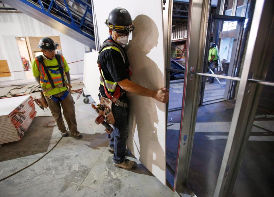 Construction workers install sheets of drywall at a building project in Calgary in a file photo from 2016.  