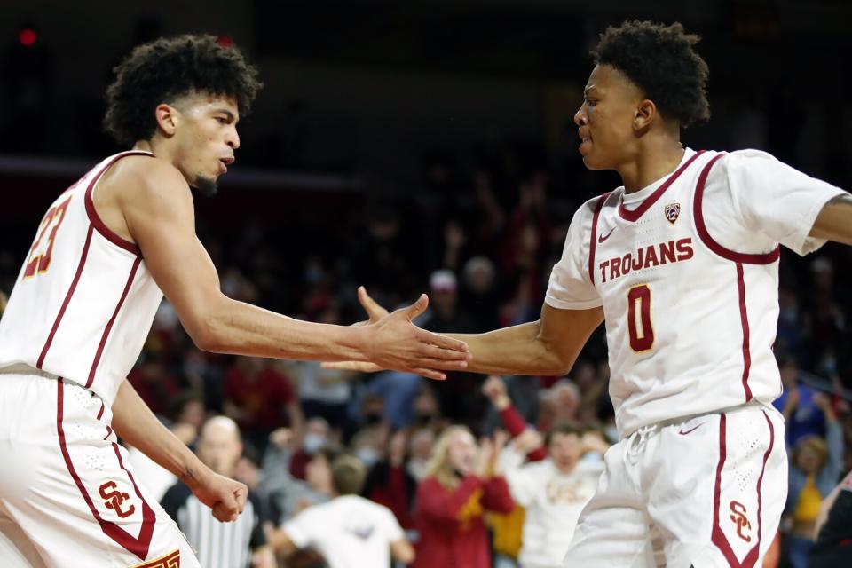 USC forward Max Agbonkpolo celebrates a dunk with guard Boogie Ellis.