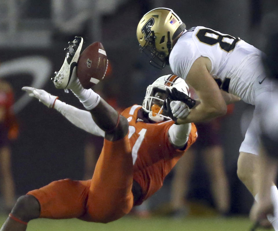 Virginia Tech's Keli Lawson (21) breaks up a pass intended for Purdue's Drew Biber (82) during the second half of an NCAA college football game in Blacksburg Va., Saturday, Sept. 9 2023. (Matt Gentry/The Roanoke Times via AP)