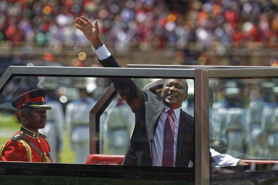 <p>Kenyan President Uhuru Kenyatta waves from behind bulletproof glass as he arrives for his inauguration ceremony at Kasarani stadium in Nairobi, Kenya Tuesday, Nov. 28, 2017. (Photo: Ben Curtis/AP) </p>