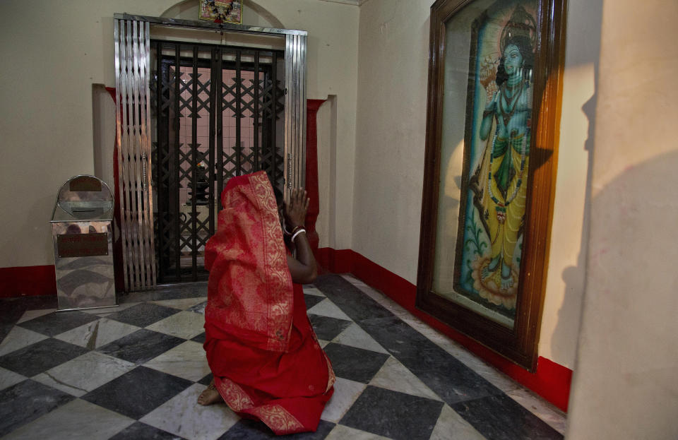 In this Tuesday, Jan. 1, 2019 photo, A Hindu woman offers prayers at the Dhakeshwari Temple in Dhaka, Bangladesh. While Sheikh Hasina is set to begin her third consecutive term as Bangladesh's prime minister following a landslide election victory, critics say having such an overwhelming majority in parliament could create space for her to become even more authoritarian. Still, Hasina enjoys a lot of support, especially from religious minorities in the Muslim-majority nation who say she has safeguarded their rights. At the Dhakeshwari Temple in Dhaka, Hindus poured in on Tuesday to pray and get a glimpse of the Goddess Durga, something they say was not possible under previous governments. (AP Photo/Anupam Nath)