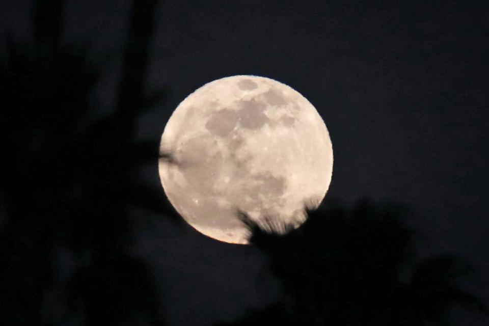 A full moon is visible at the Desert Empire League track and field finals in Palm Desert, Calif., on Tuesday, April 23, 2024.