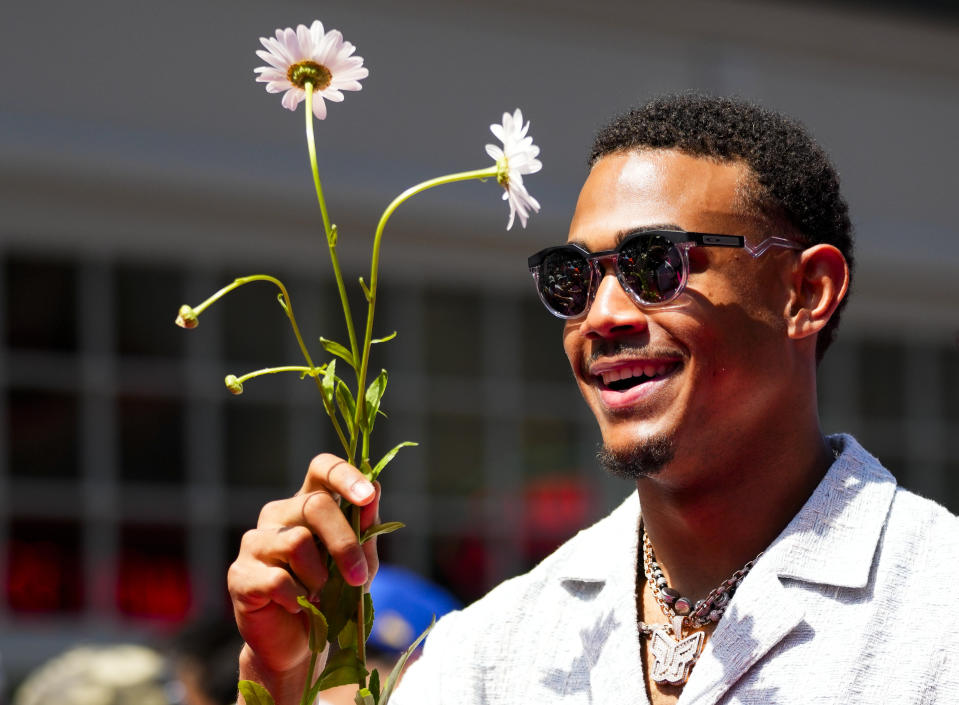 American League's Julio Rodriguez, of the Seattle Mariners, holds flowers during the All-Star Game red carpet show, Tuesday, July 11, 2023, in Seattle. (AP Photo/Lindsey Wasson)
