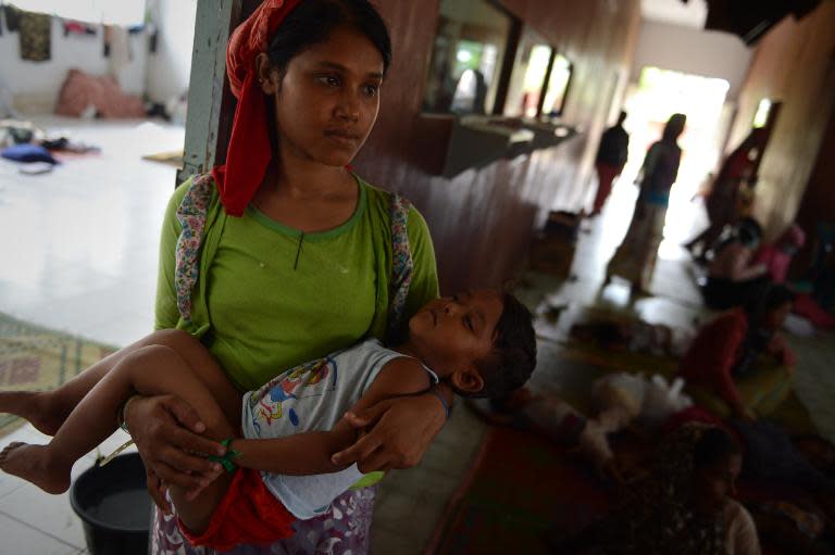 Rohingya women and children gather at a confinement area for migrants at Bayeun, in Indonesia's Aceh province, on May 22, 2015, after being rescued from sea