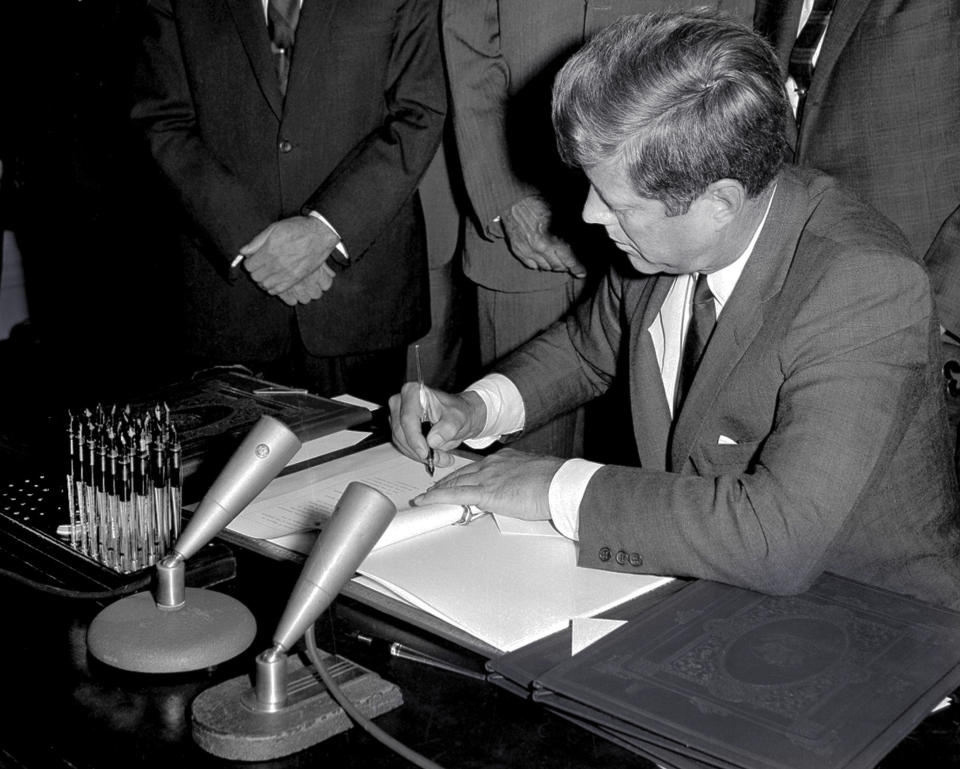 FILE - In this Oct. 7, 1963, file photo, President John F. Kennedy signs the Limited Test Ban Treaty during a ratification ceremony in the White House Treaty Room in Washington. Nuclear disarmament might seem like a must-discuss topic in world leaders' annual speeches at the U.N. General Assembly, which has espoused that cause since its founding. And the assembly's big annual meeting this Sept. 2021, came in a year that marked the entry into force of one nuclear weapons treaty and the anniversary of another. (AP Photo/File)