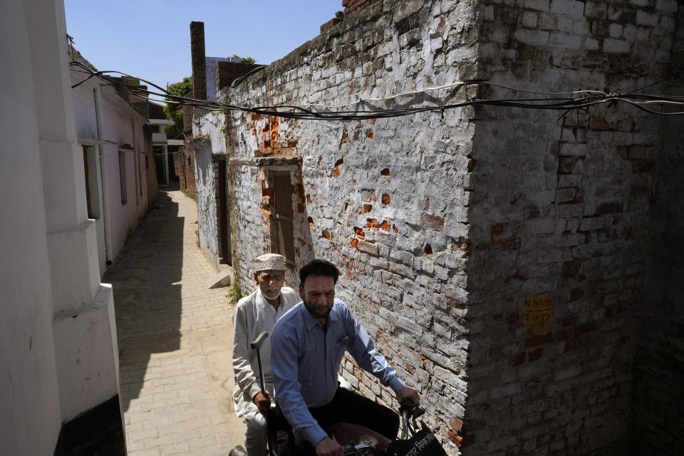 A Muslim man takes his ailing father on a motorcycle to see a doctor through the narrow lanes of Ayodhya, India, March 28, 2023. India is home to some two hundred million Muslims who make up the predominantly Hindu country's largest minority group. They are scattered across almost every part of India where a systematic anti-Muslim fury has swept since Prime Minister Narendra Modi first assumed power in 2014. (AP Photo/Manish Swarup)