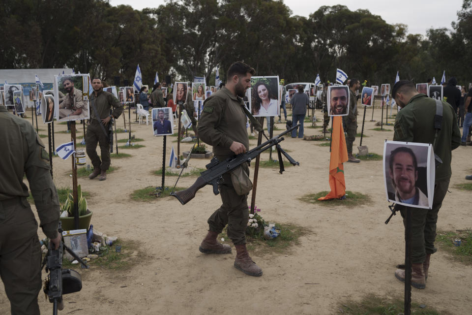 An Israeli soldier visits the site where revelers were killed on Oct. 7 in a cross-border attack by Hamas at the Nova music festival in Re'im, Southern Israel, Sunday, Jan. 21, 2024, during an event where friends and relatives are planting trees in memory of their loved ones. (AP Photo/Leo Correa)