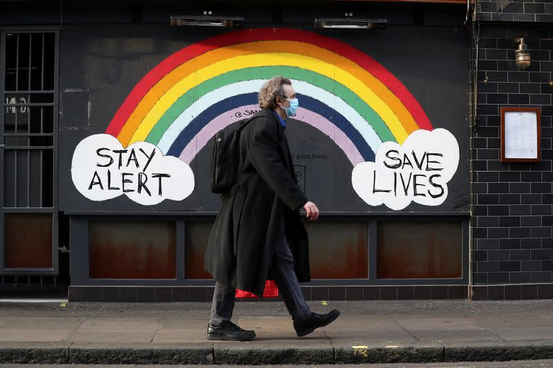 A pedestrian walks past street art in Soho amid the coronavirus disease (COVID-19) outbreak in London