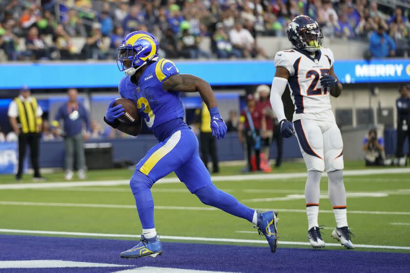 El corredor de los Rams de Los Ángeles Cam Akers anotando superando al cornerback de los Broncos de Denver Damarri Mathis en el encuentro del domingo 25 de diciembre del 2022. (AP Foto/Jae C. Hong)